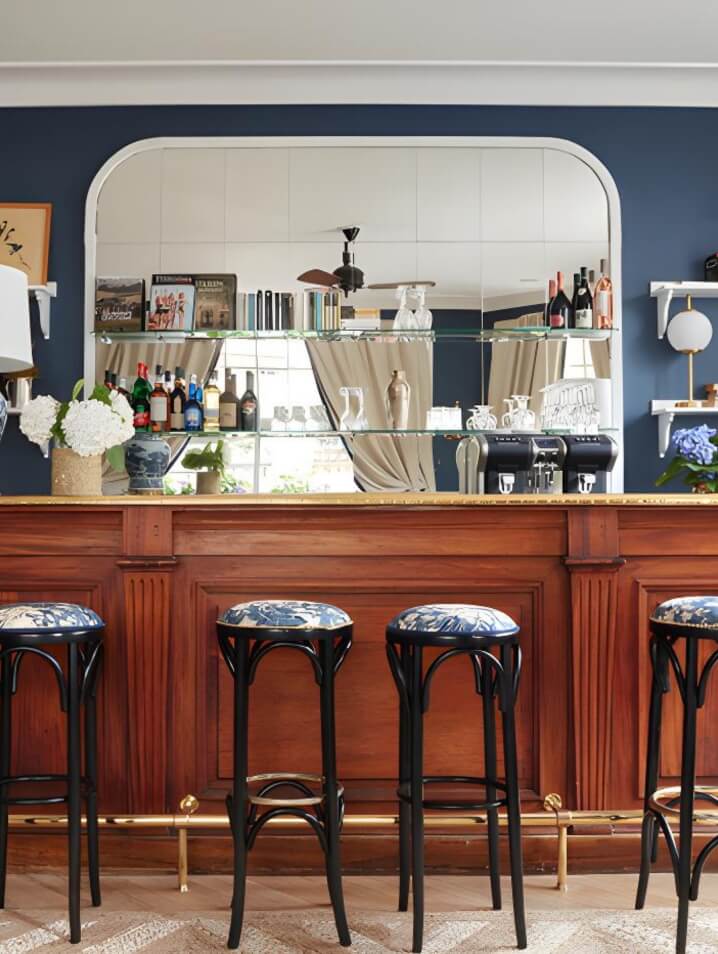 Luxurious Faulbert Hotel in Normandy with an intimate, cozy bar with blue accents and upholstered stools.