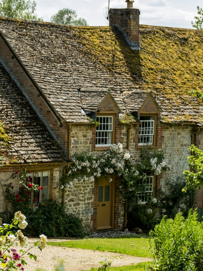 Stone house facade adorned with white flowers above the door.