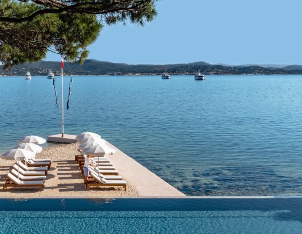 The Cheval Blanc in St. Tropez, offers a seaside pool with white chaise lounges overlooking the Mediterranean Sea.