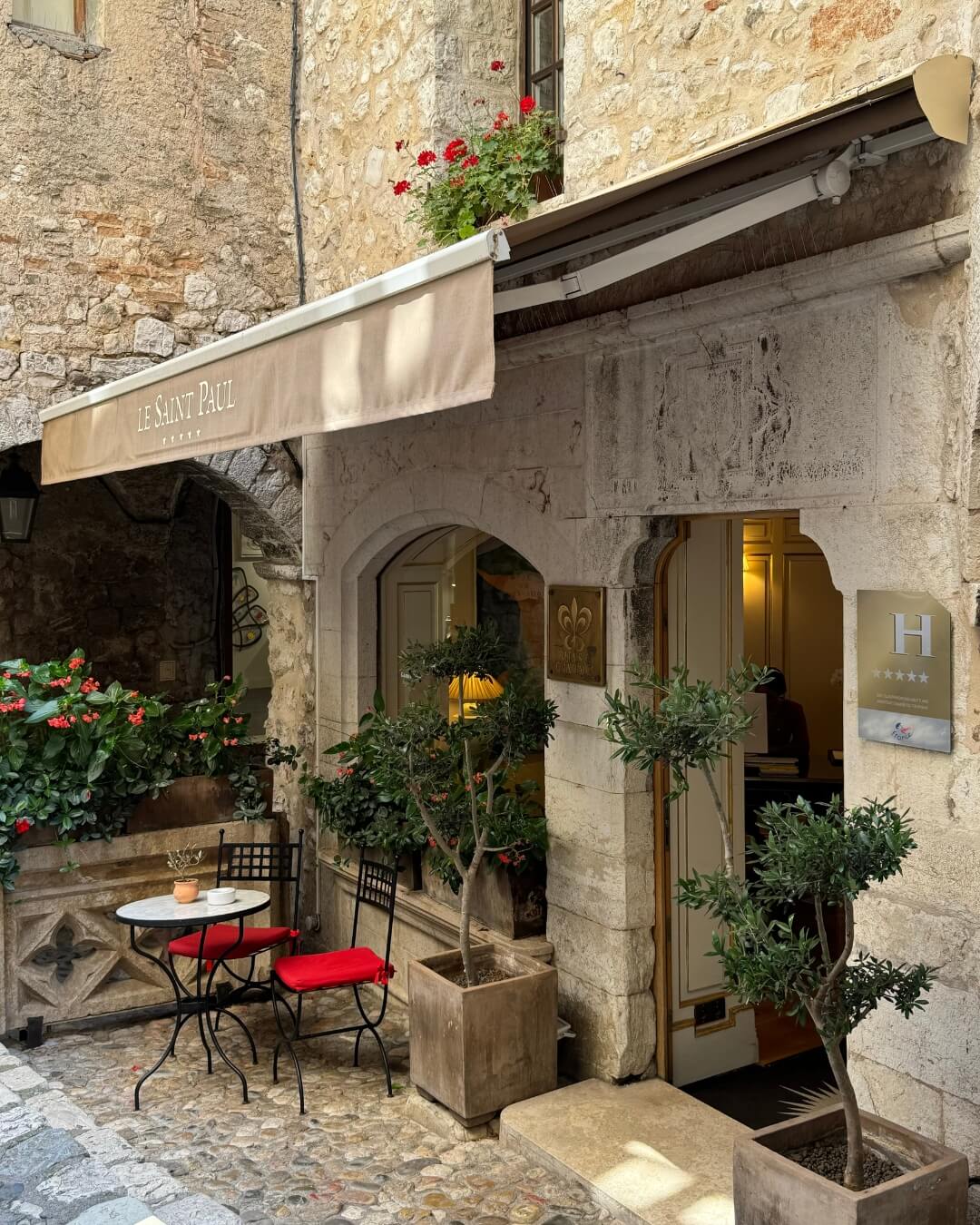 Le Saint-Paul hotel in the French Riviera with a charming stone walkway and outdoor seating at the entrance.
