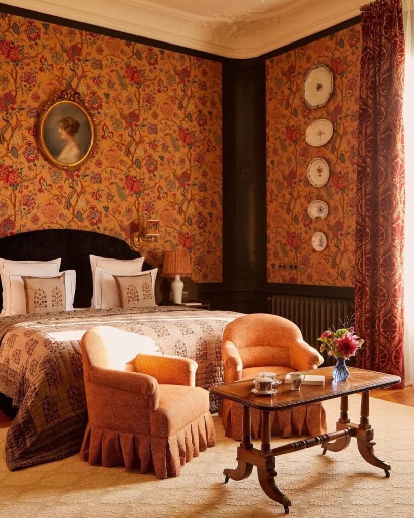 Room in the Abbaye Vaux de Cernay with floral wallpaper, cozy decor, and natural warm light.