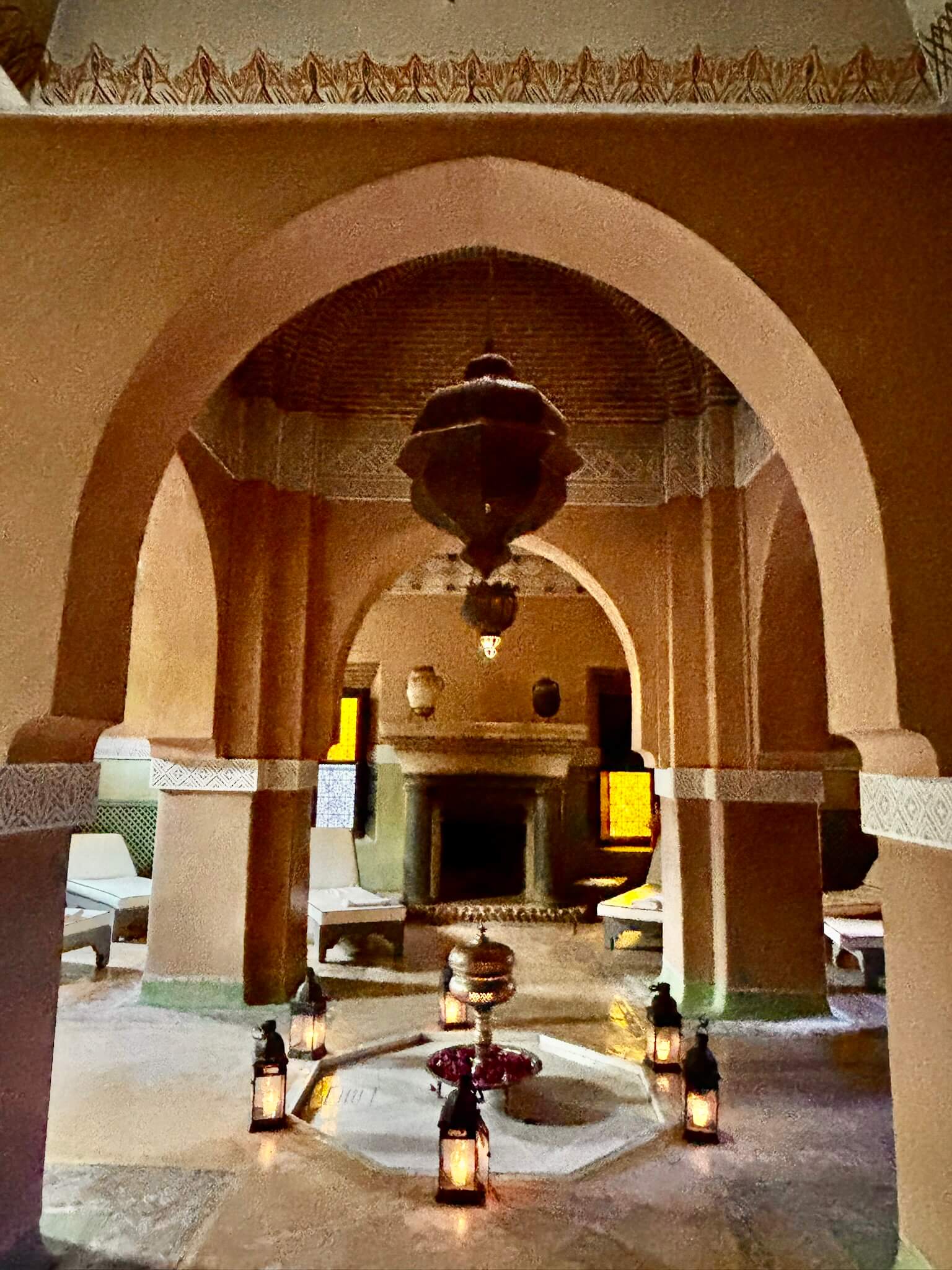 Moroccan style archway of Marrakesh boutique hotel decorated with lanterns and and lounge chairs.