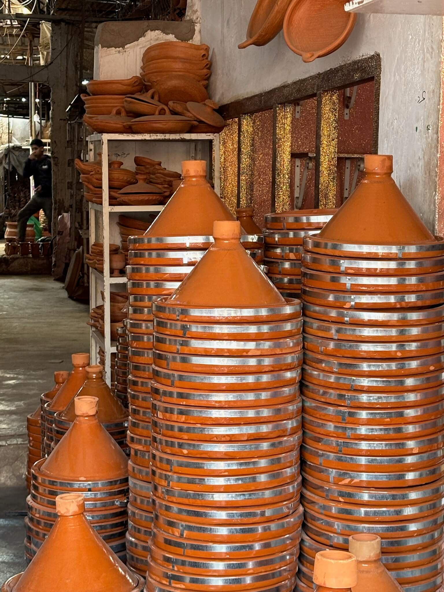 Moroccan pottery house with stacked traditional red clay cookware.