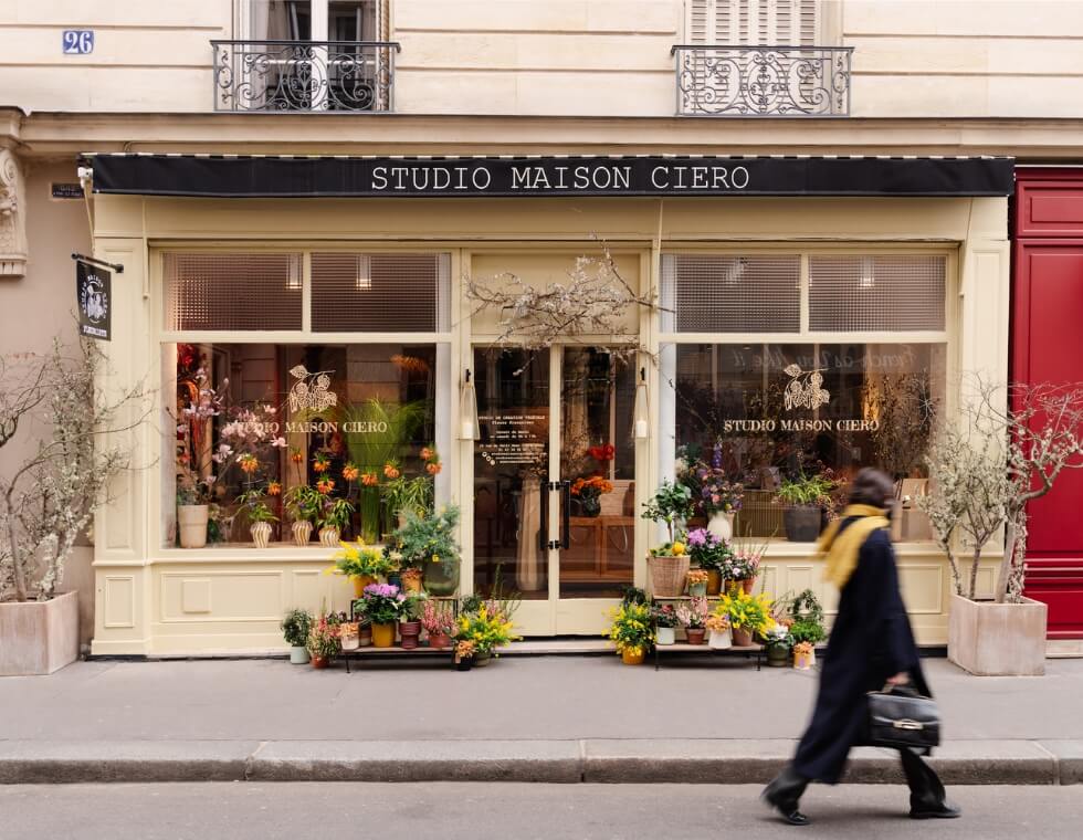 Studio Maison Ciero flower shop facade in Paris, France featuring bright open windows and colorful blooms.
