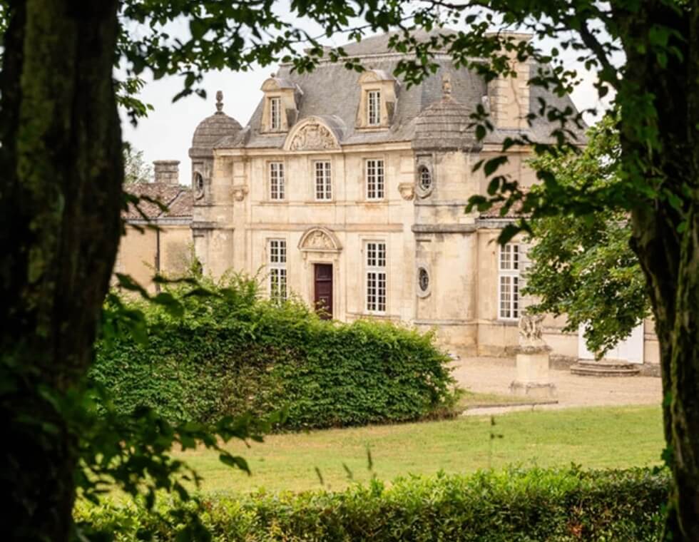 Château de Malle vineyard in Preignac, France, featuring traditional stone architecture and lush greenery.
