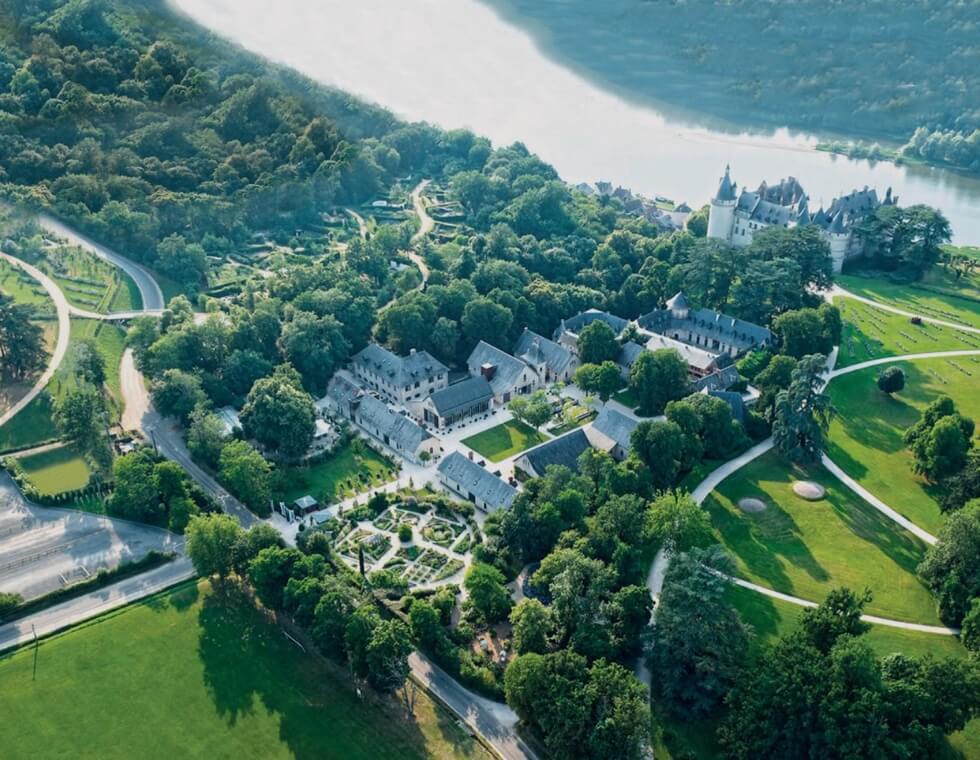 View of Chaumont Castle in the Loire Valley, France, featuring French gardens, natural greenery, and a lake in the distance.