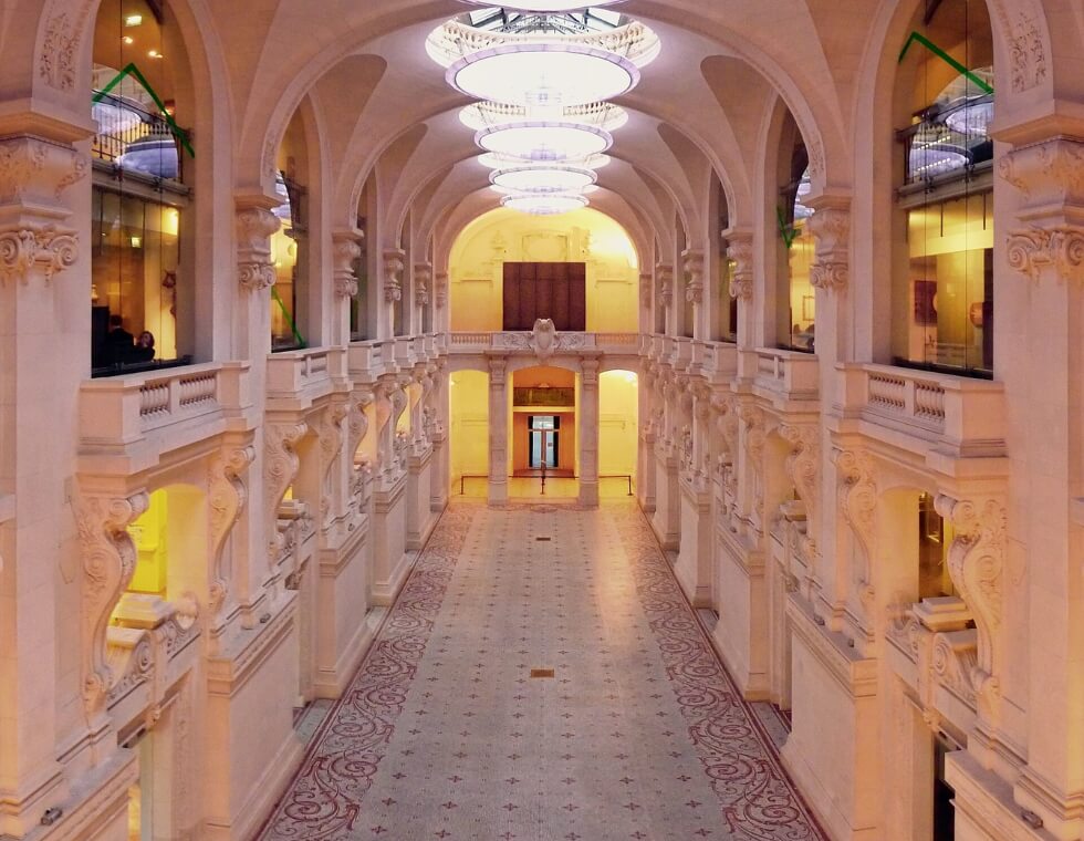 Interior hall of the Museum of Decorative Arts in Paris with elegant carved stone walls.