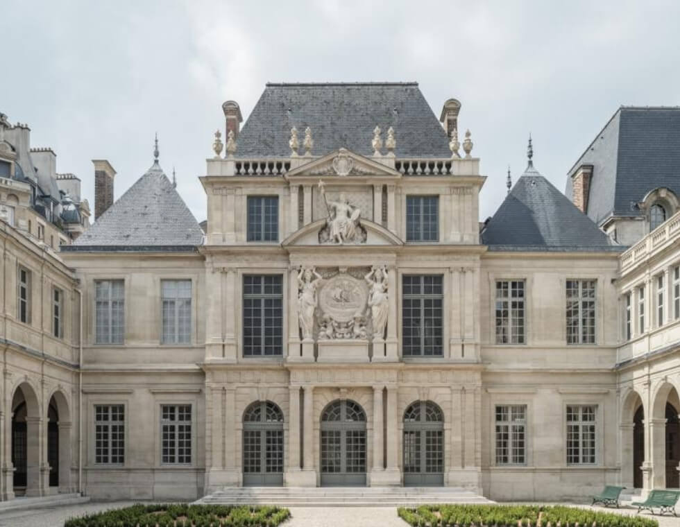 Facade of the historic Carnavalet Museum in Paris, France, featuring elegant stone statues.