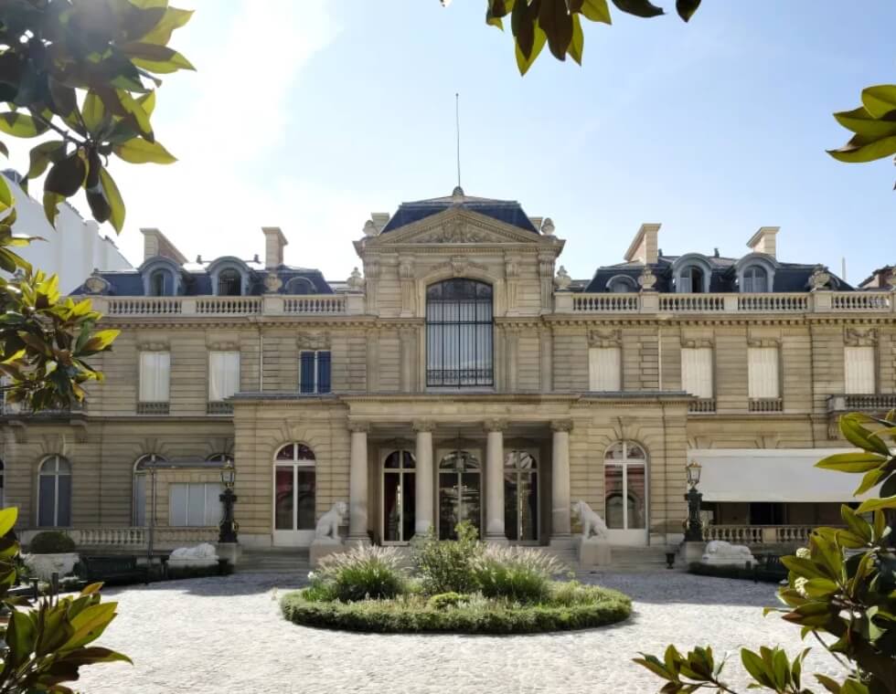 Jacquemart-André Museum in Paris, France, featuring a traditional garden and stone pebble walkway.