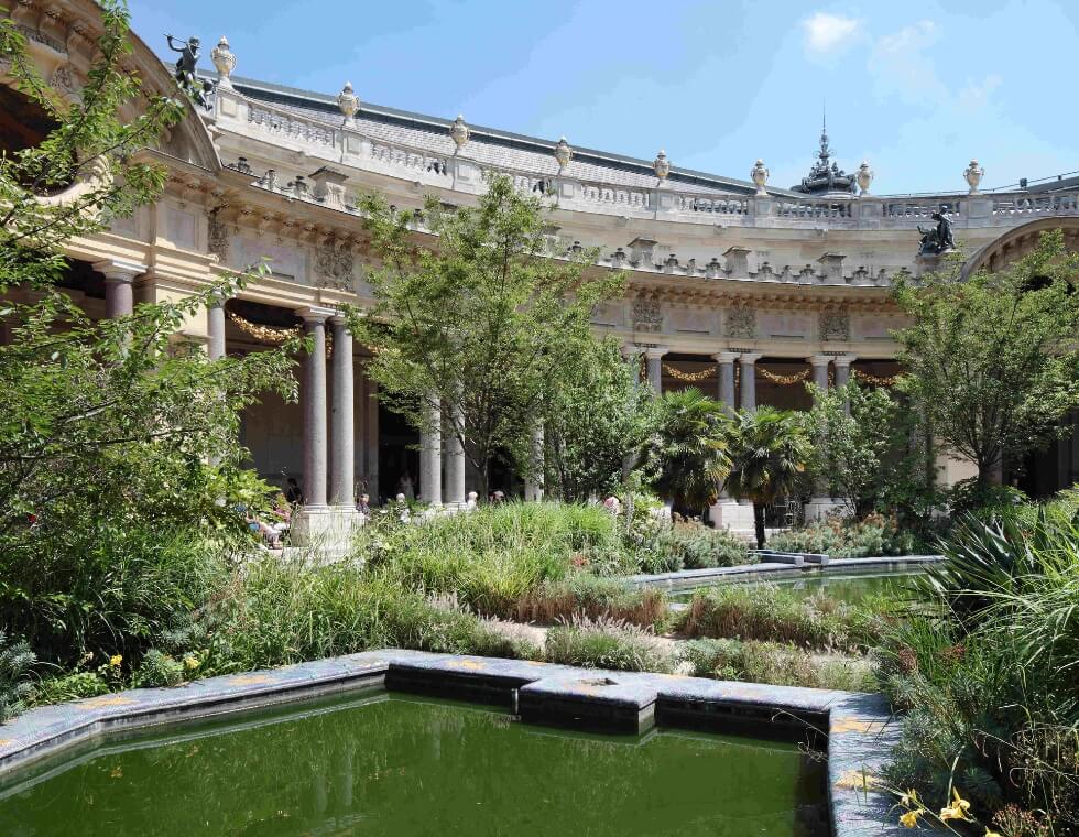 Lush green garden tucked behind the Petit Palais in Paris, France.
