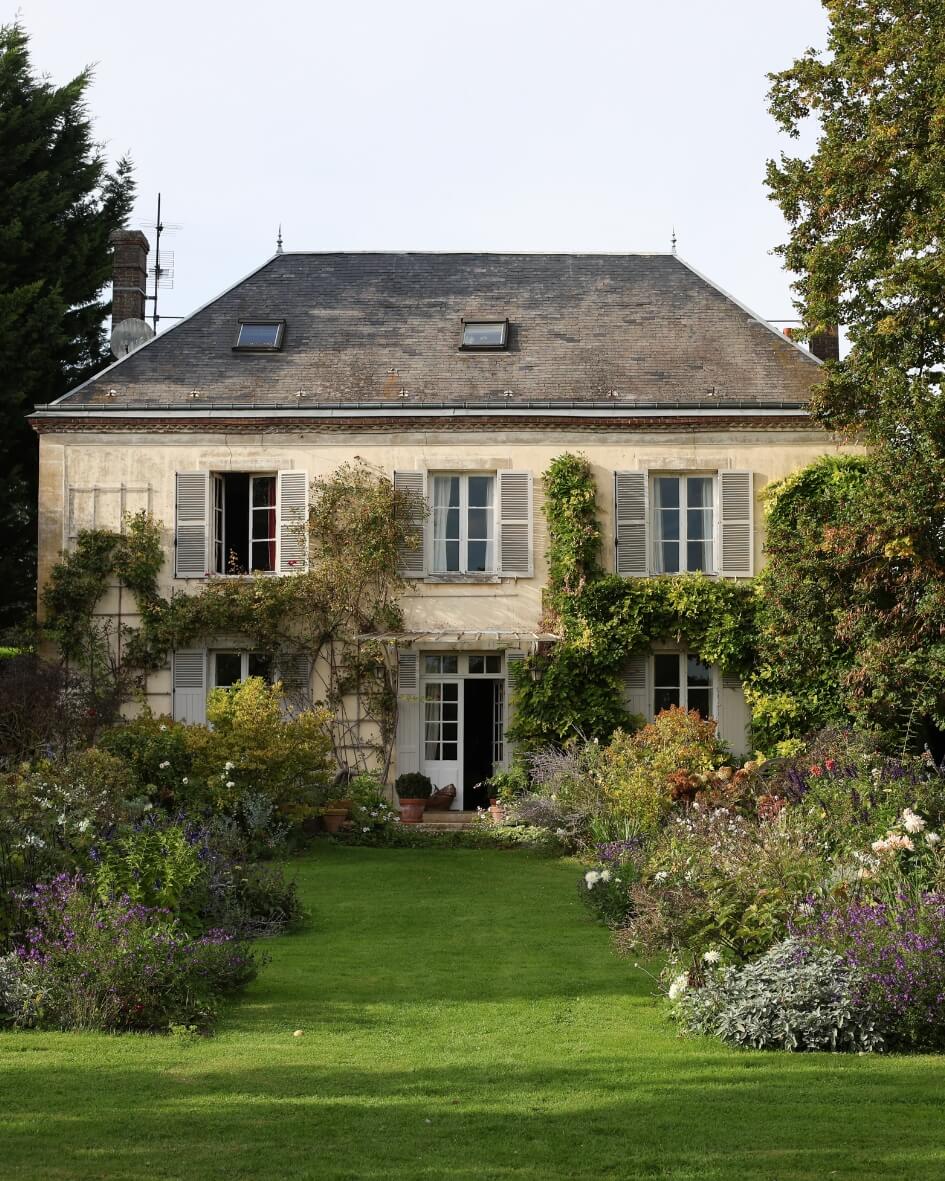 Countryside home in Normandy, France with a sprawling garden and lush green grass.