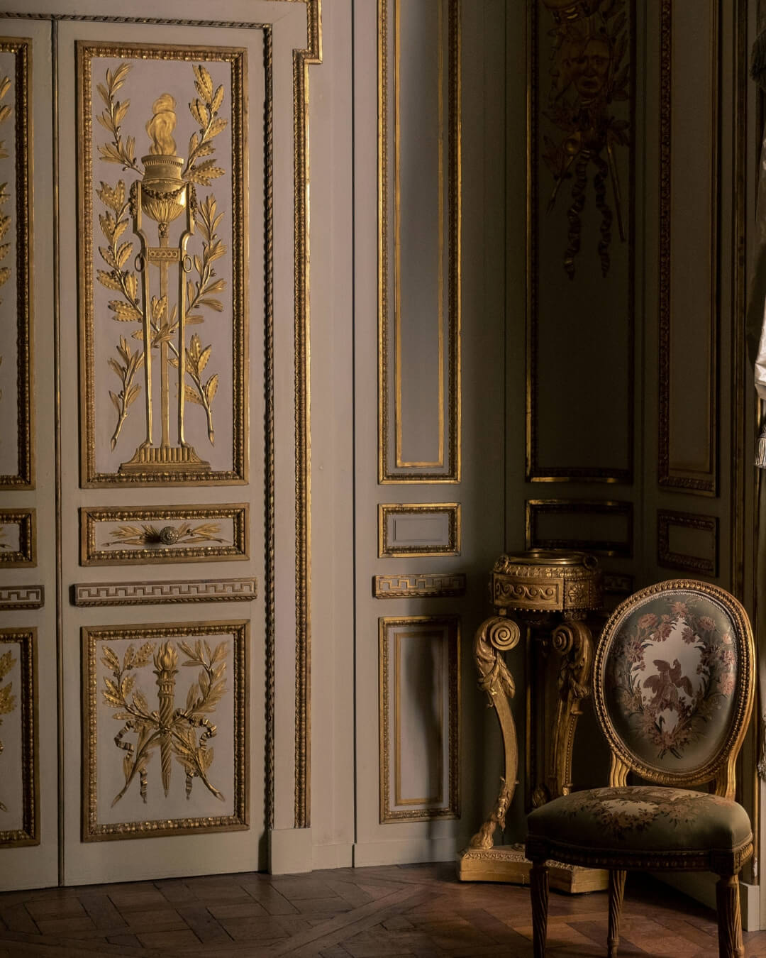 Historic Parisian salon with gold leaf fixtures and an ornately upholstered chair.