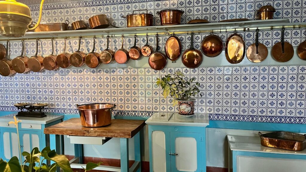 Normandy home kitchen with featuring array of copper pots and cookware.
