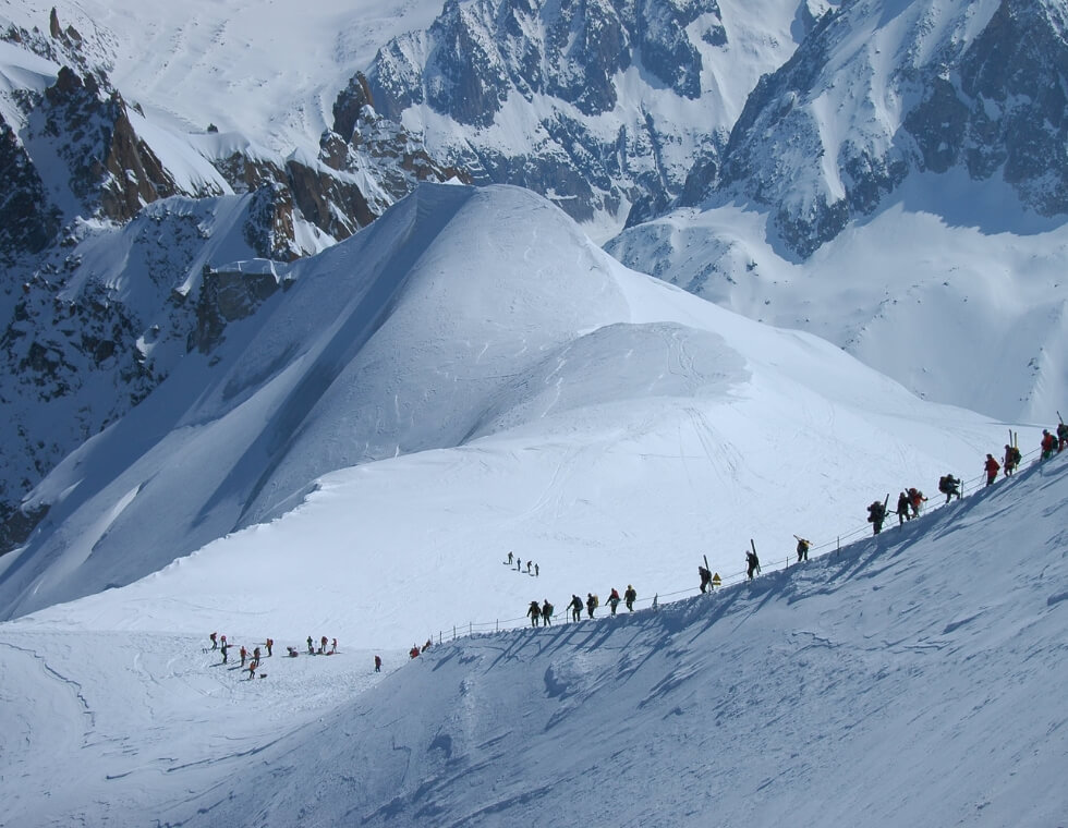 Skiers hiking pristine snowy peaks in Chamonix, the French Alps.