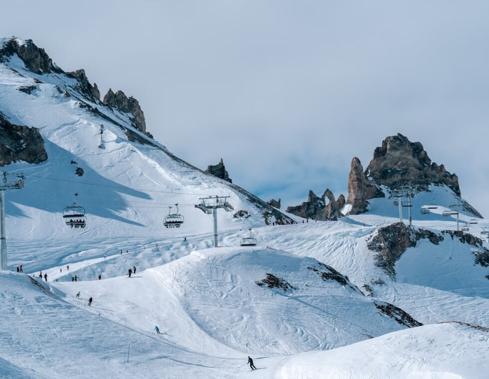 Val d’Isère ski slopes with skiers and snowboarders in the French Alps.