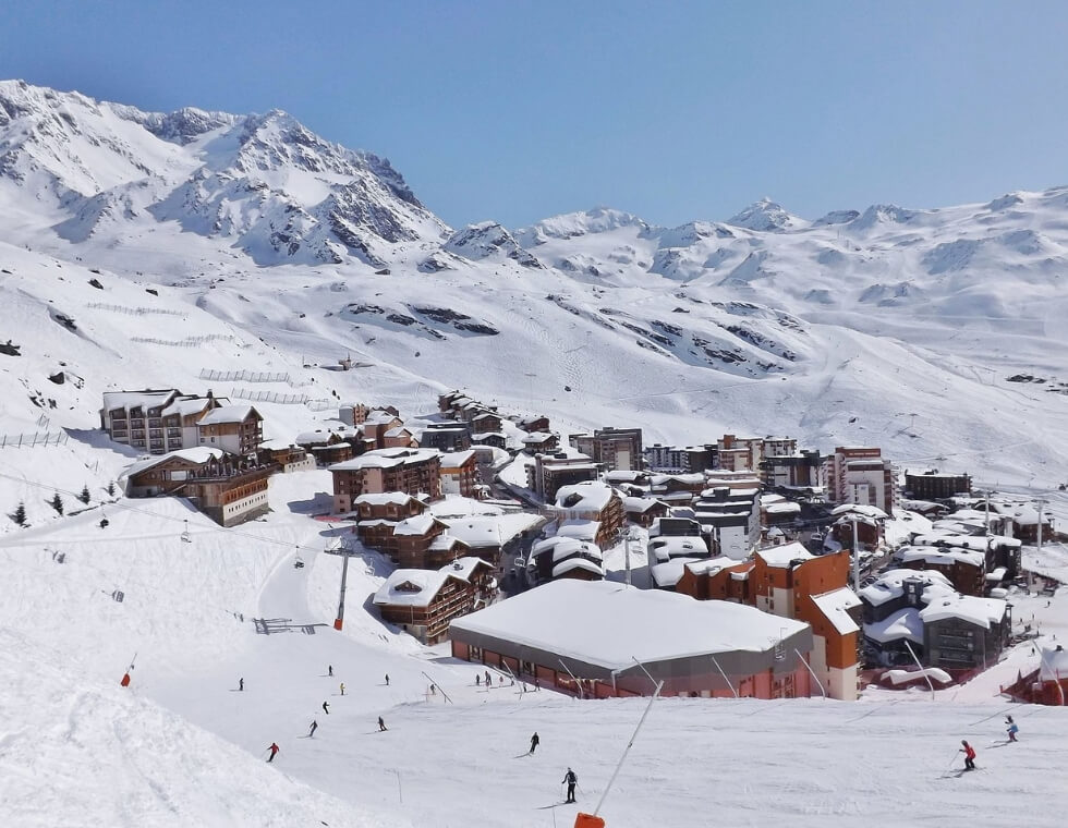 Val Thorens ski resort with skiers on snowy surrounding slopes.
