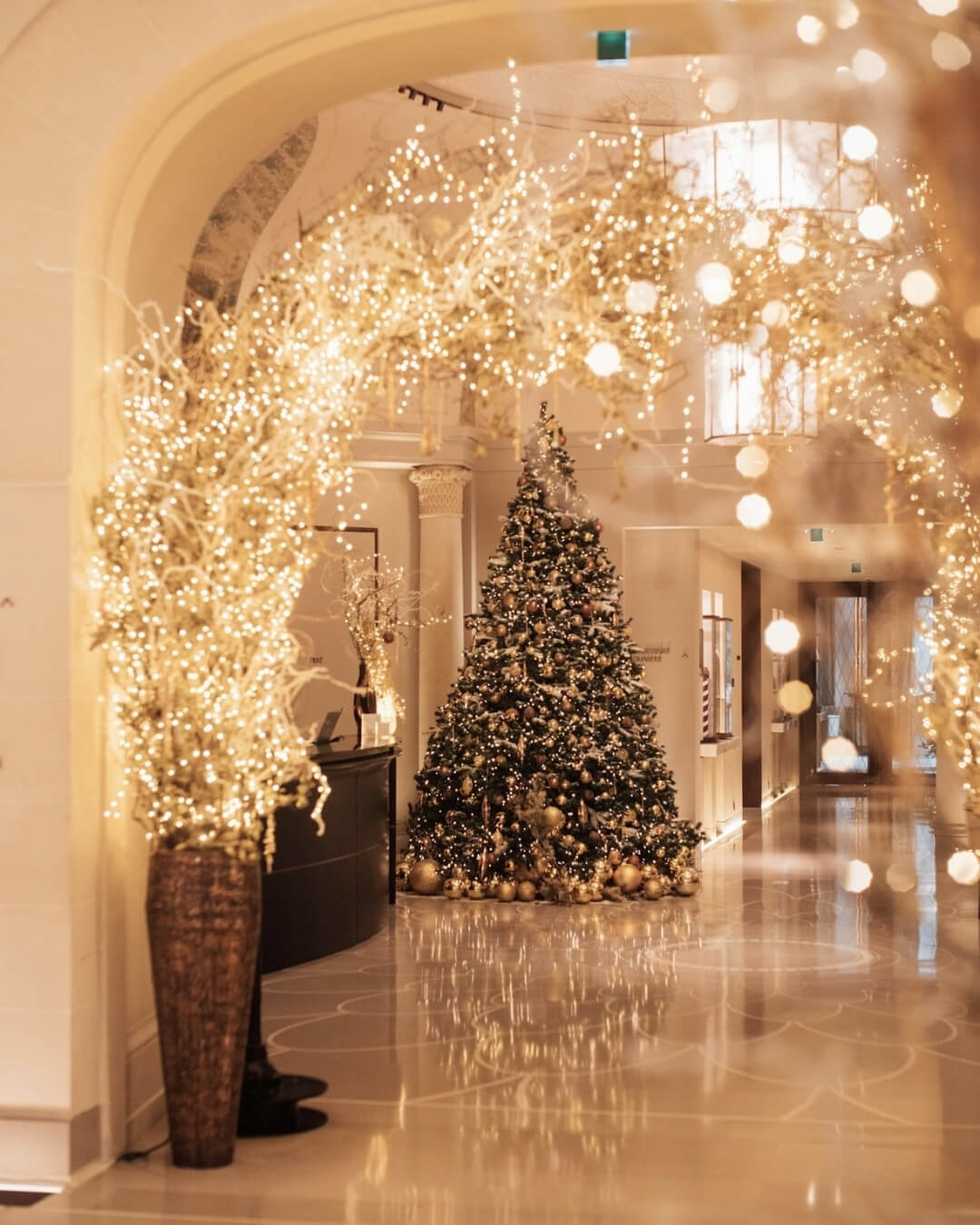 Interior of the Lutetia Hotel in Paris decorated with festive holiday lights and a Christmas tree.