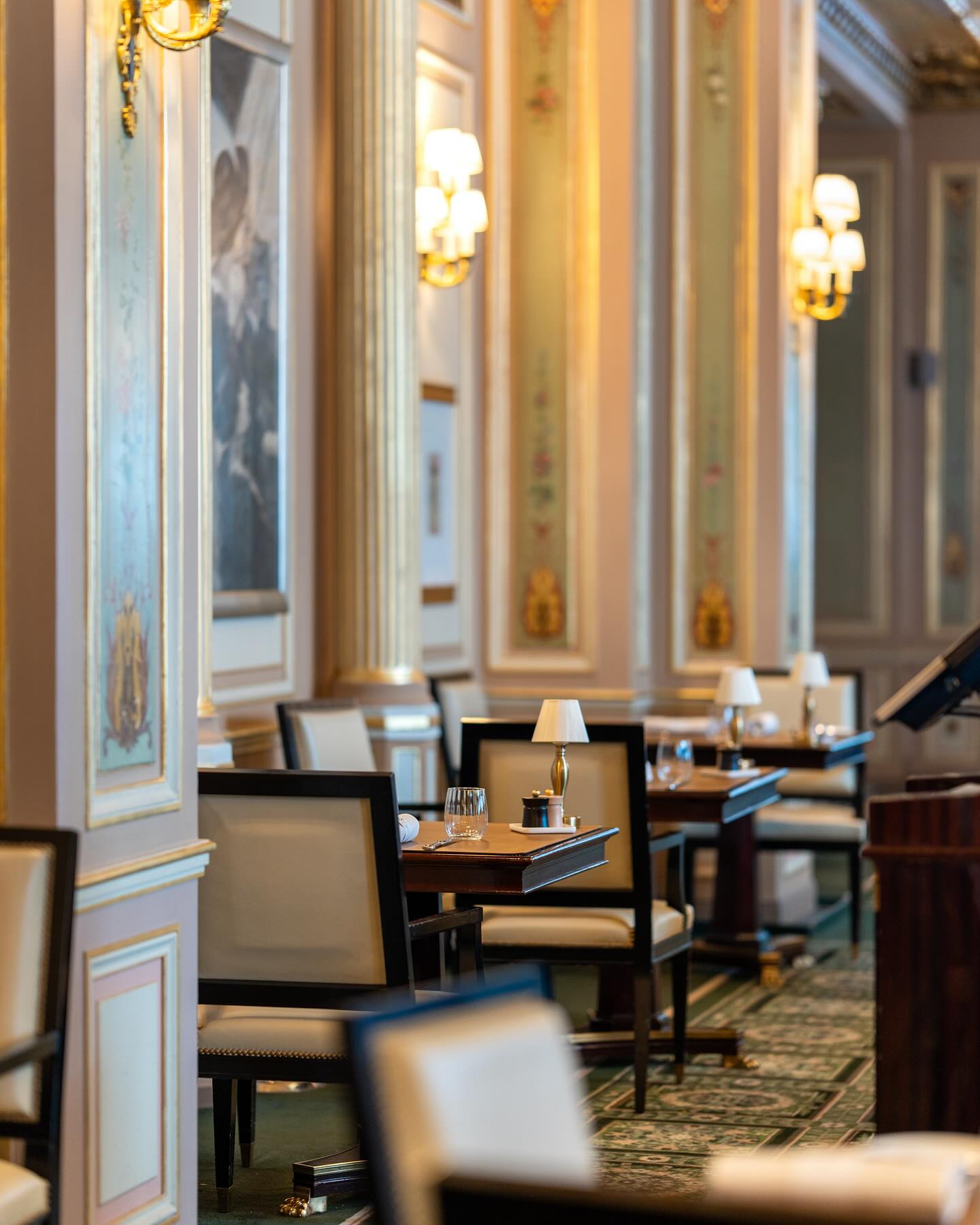 Cafe de la Paix in Paris, France with iconic artistic motifs, soft lighting, and intimate dining tables.