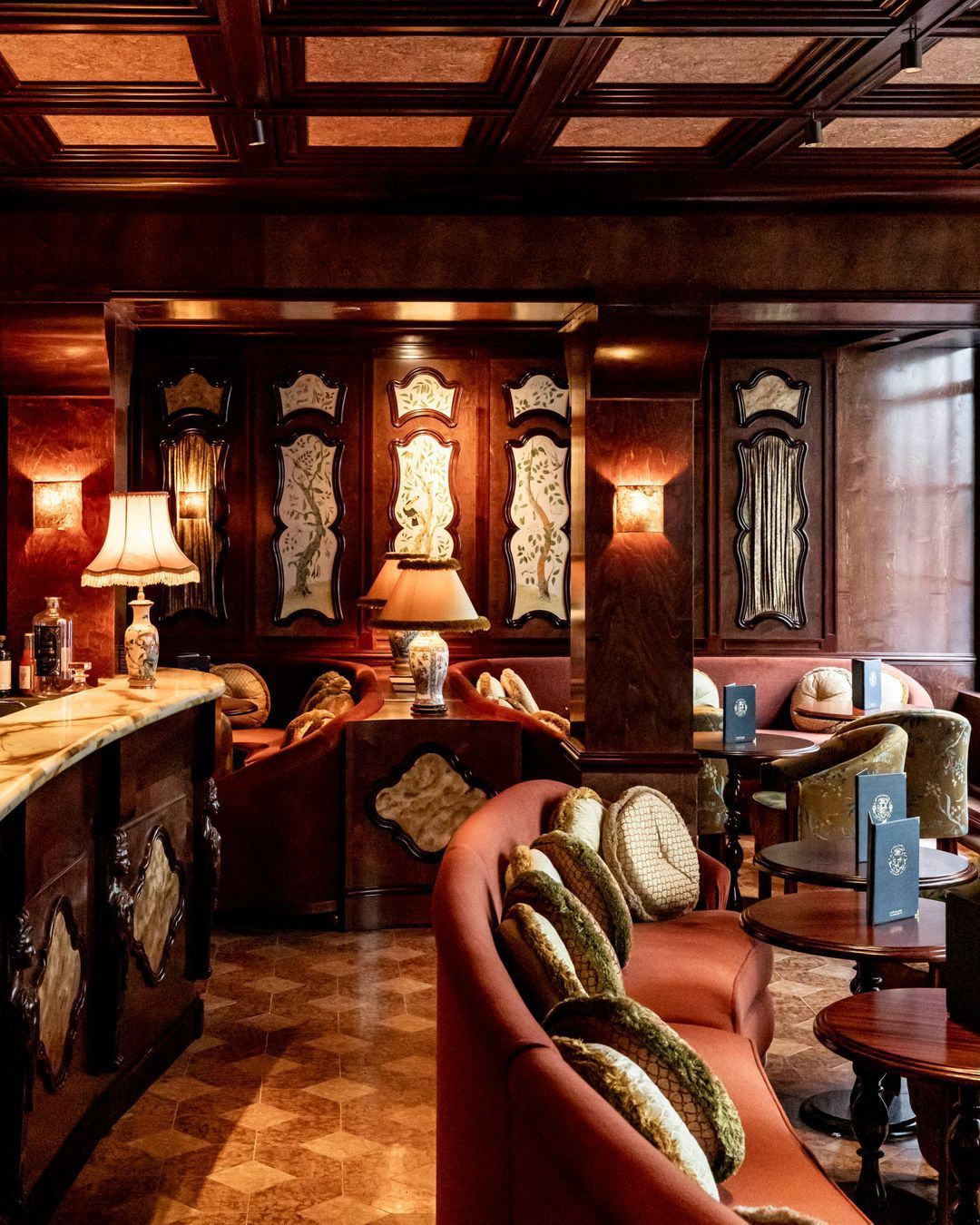 Le Procope restaurant interior in Paris, France with warm art deco accents, plush seating, and vintage wood paneling.