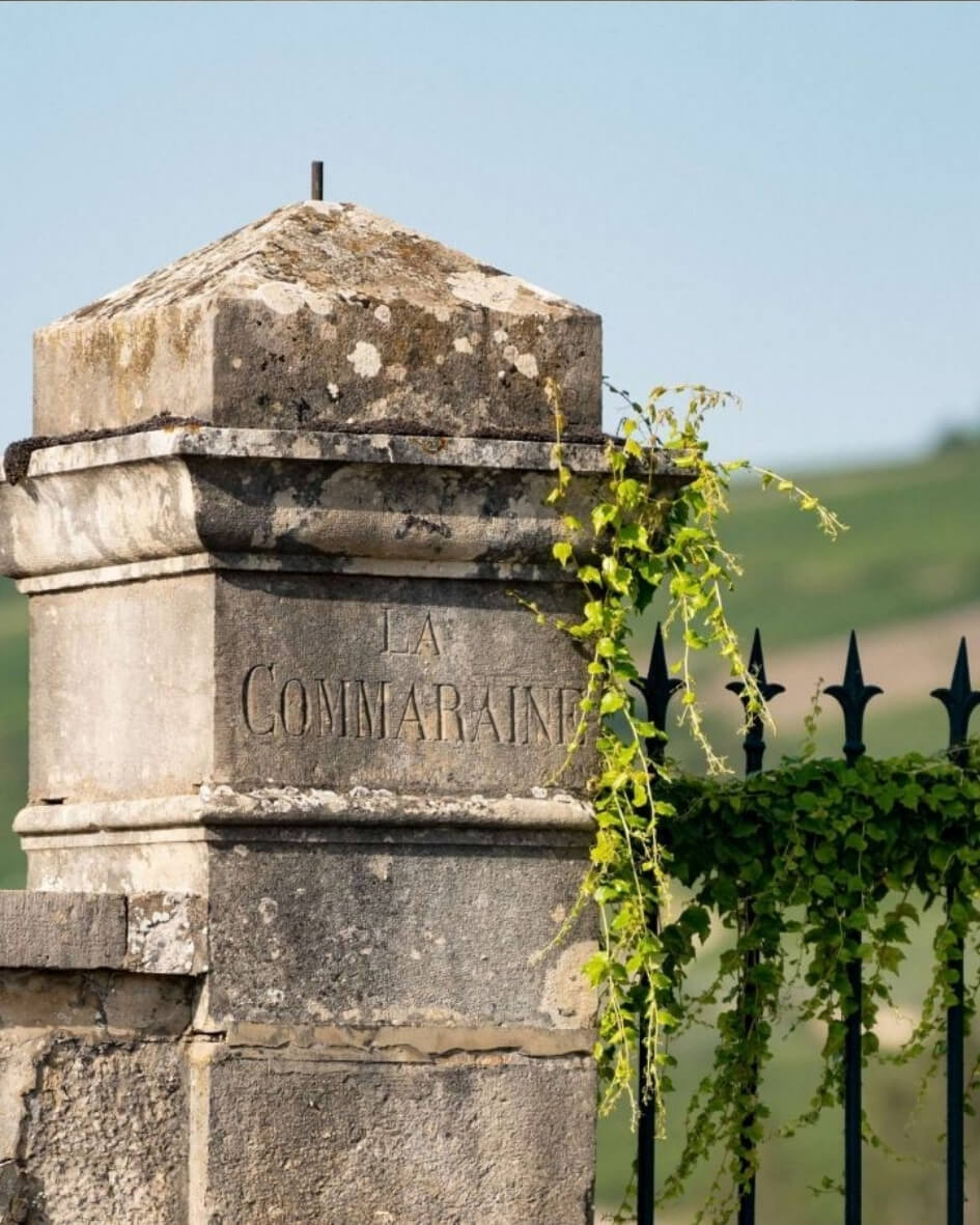 Historic stone marker engraved with 'La Commaraine' at the entrance gate of The Château la Commaraine Hotel.