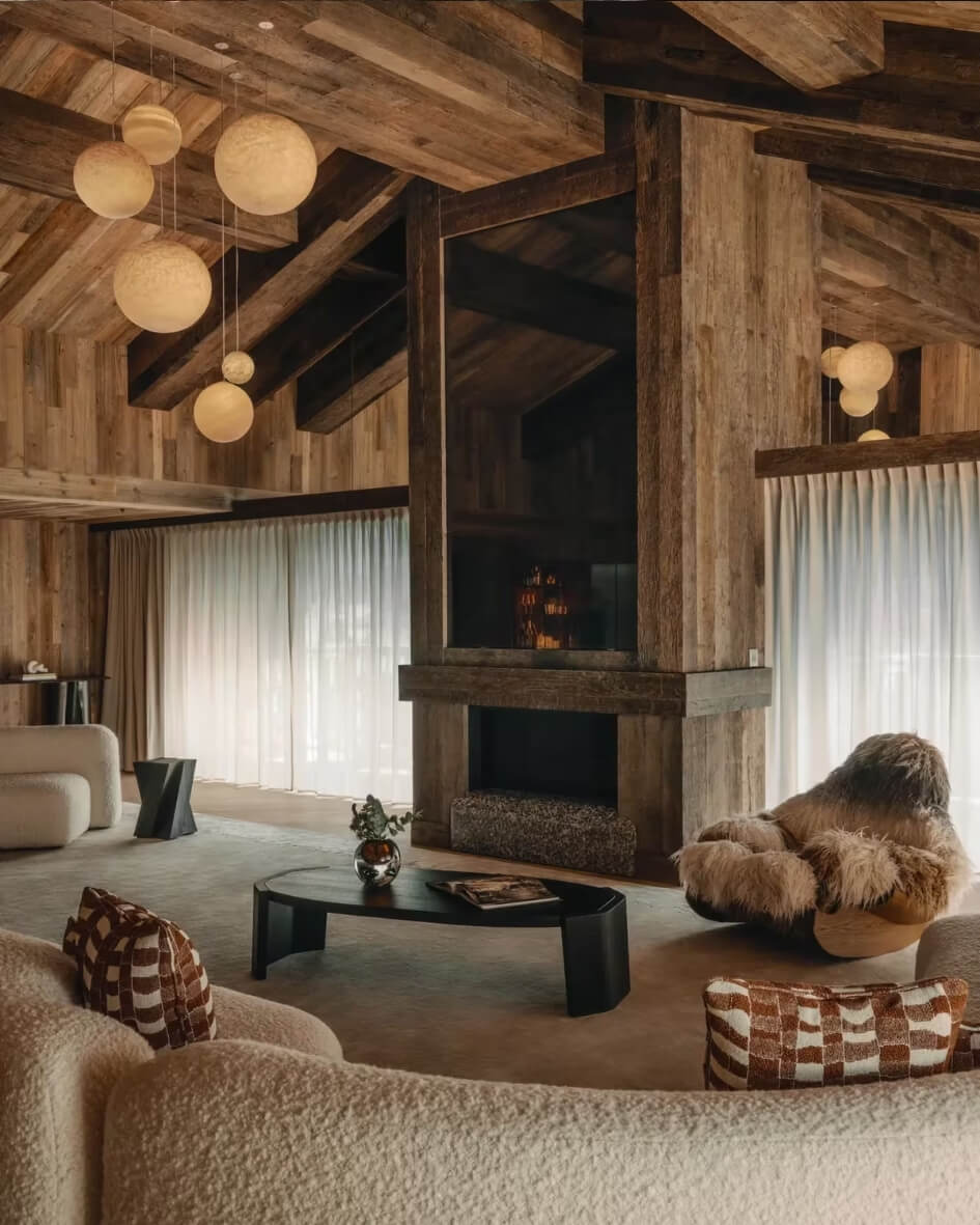 Interior of the Rosewood Courchevel ski chalet with cozy seating, exposed wooden beams, and modern light fixtures.