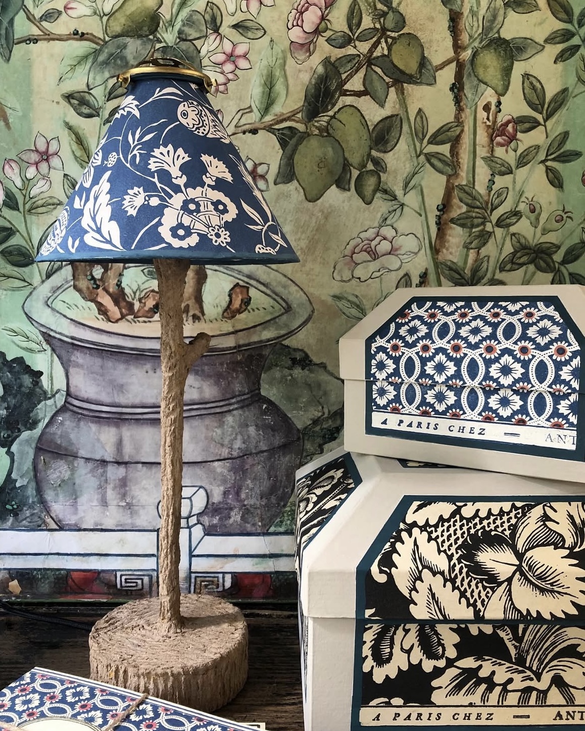 Handcrafted lamp shade by A Paris Chez displayed against a colorful tapestry.