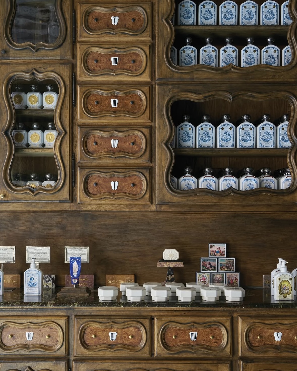 Close up image of art deco apothecary drawers, cabinets, and inspired beauty products at Officine Universelle Buly in Paris.