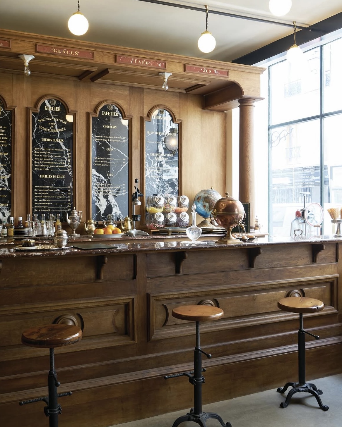 Antique pharmacy style cafe at Officine Universelle Buly in Paris, France with vintage seating and decor.