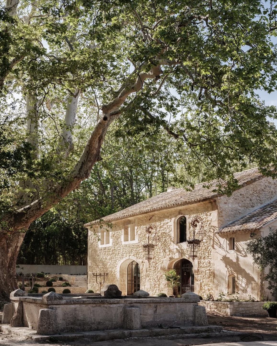Stone villa in Castillone, Provence, sunlit and surrounded by trees.