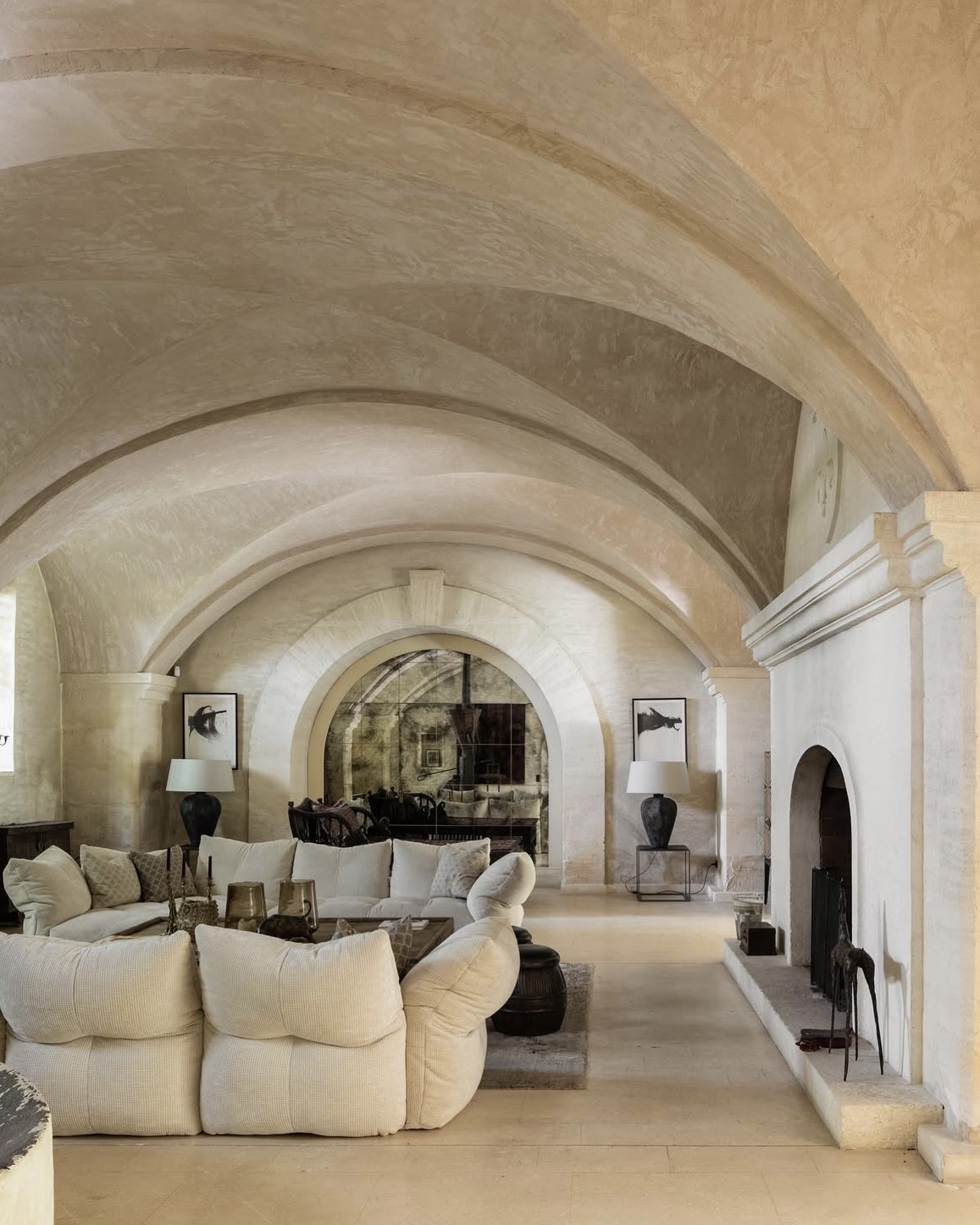 Mas de Chabran villa interior with vaulted stone ceilings, plush seating, and minimalist design accents.
