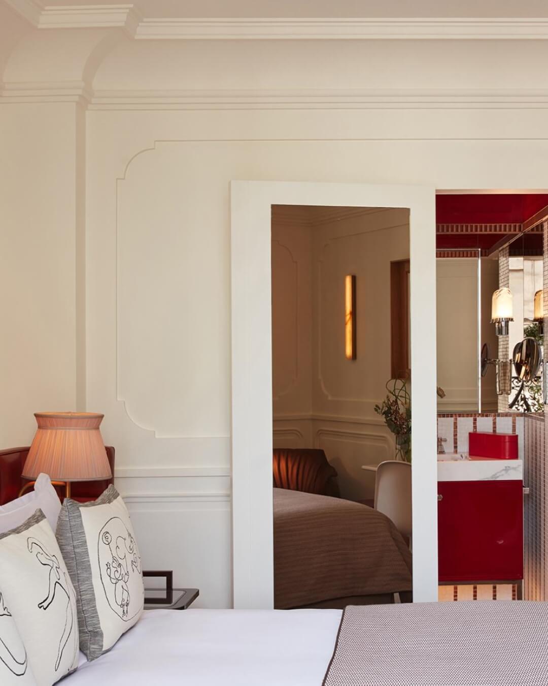 Villa des Pres boutique hotel room in Saint Germain, Paris with a plush made bed, white linens, and bright natural light.