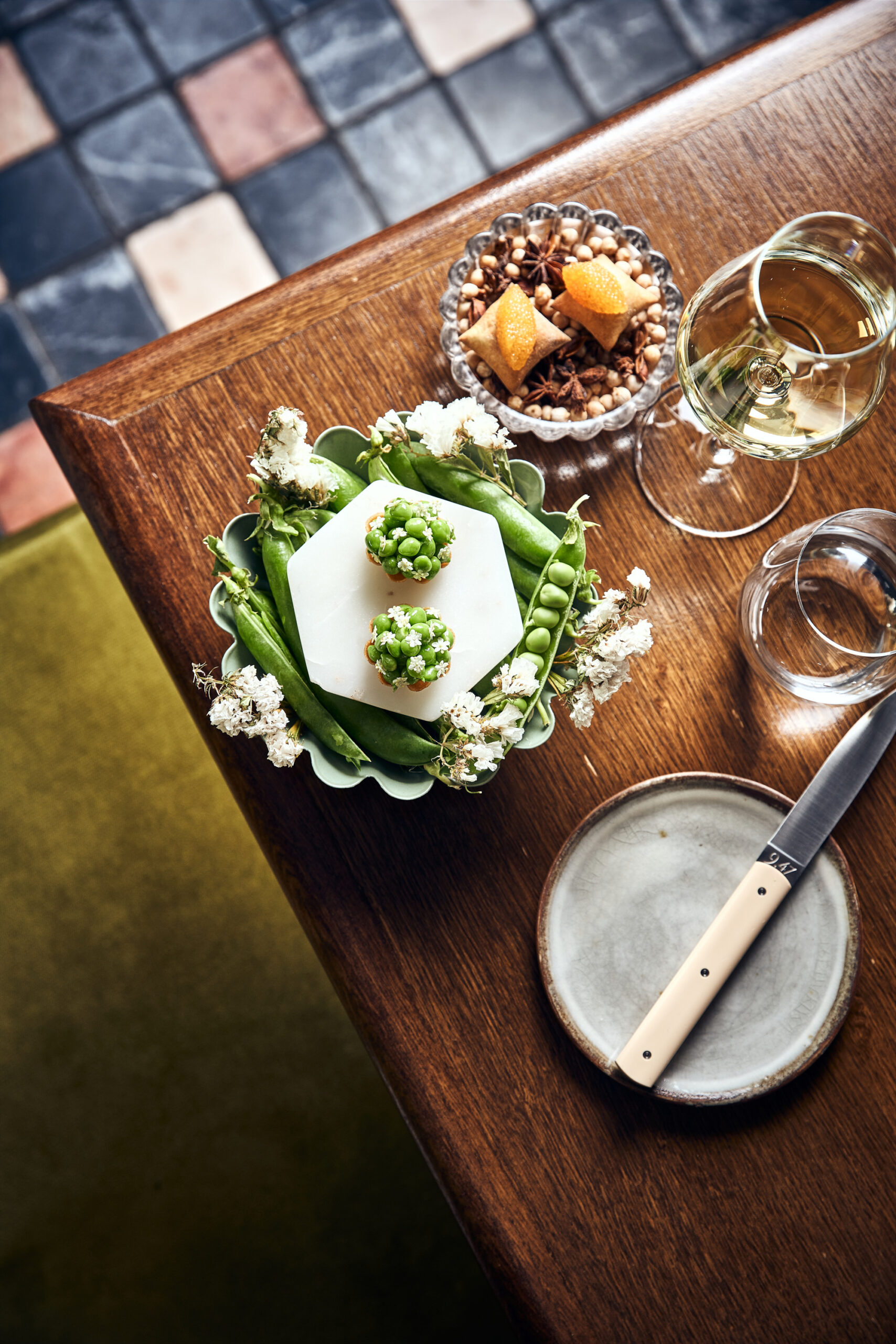 Snow peas and wine displayed on a wooden table in a French restaurant.