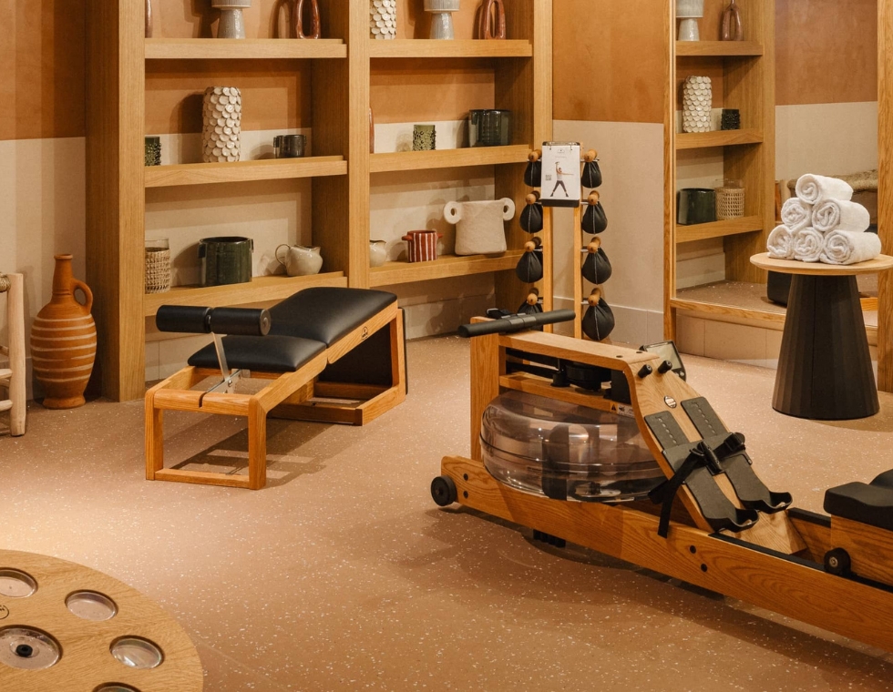 Bloom hotel spa and gym with minimalist wooden gym equipment and decorative pottery.
