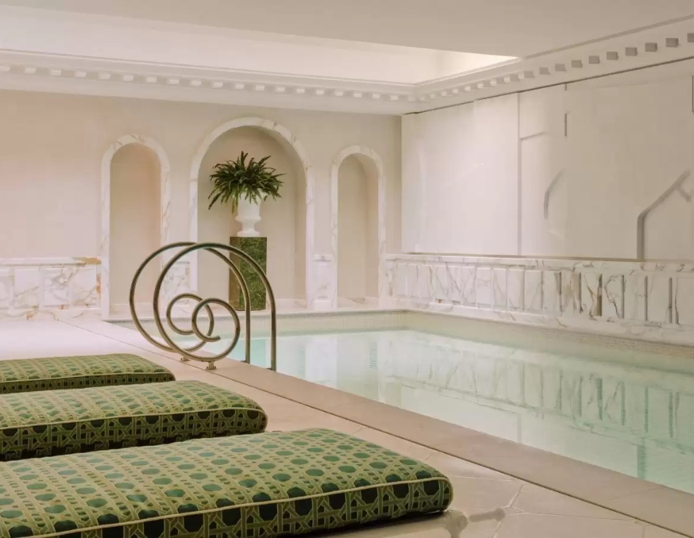Luxury indoor pool with marble walls and green chaises at Saint James Hotel & Spa in Paris.