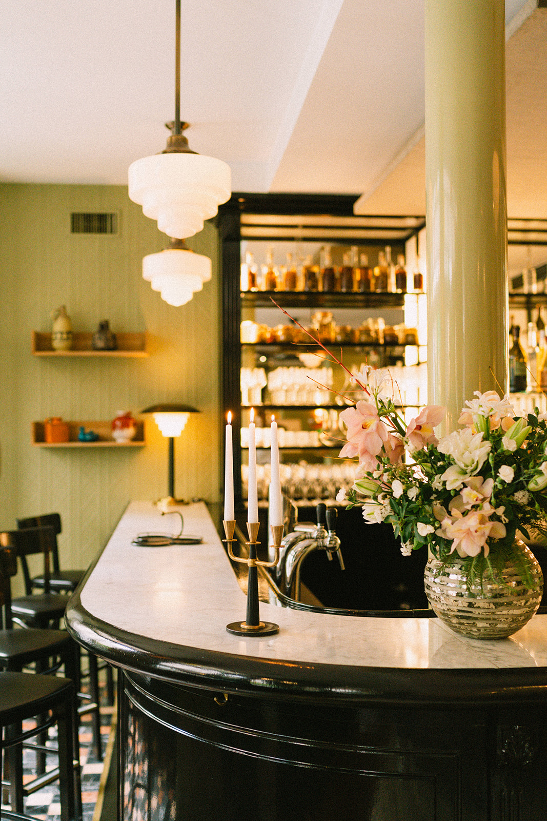 Virtus restaurant in Paris, France with green accents, vintage fixtures, and soft candle light.