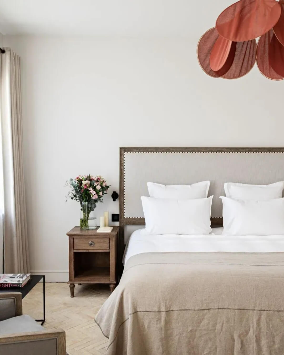 Domaine de Primard hotel-room interior with a plush made bed, minimal decorative accents, and soft natural light.