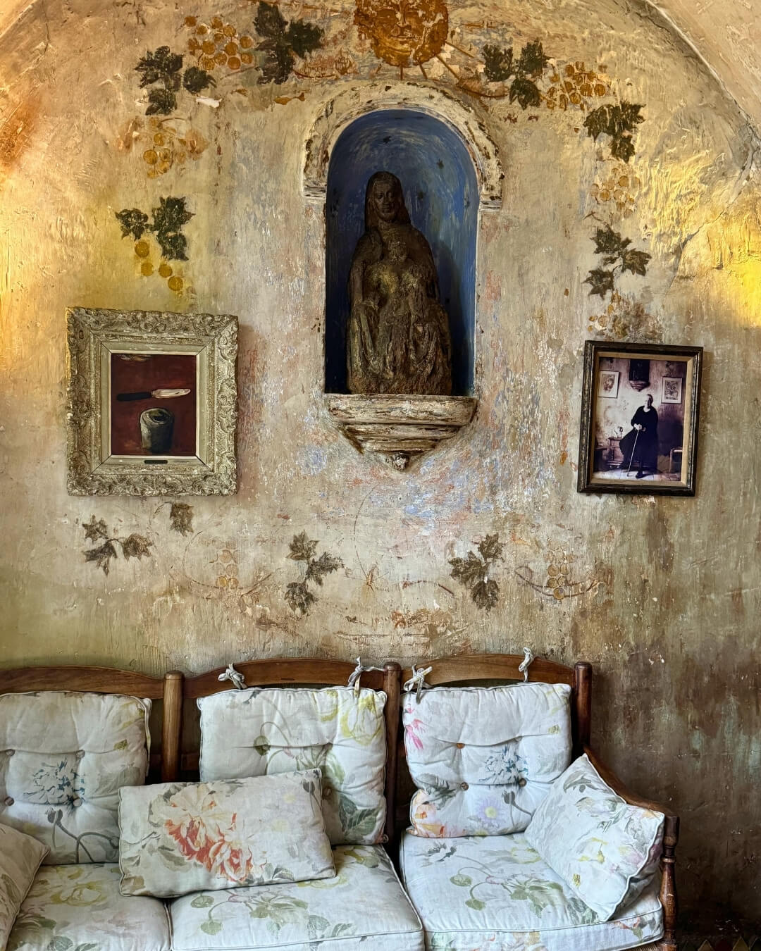 La Colombe d'Or hotel interior in Saint Paul de Vence, with vintage seating, antique French art, and painted frescos.