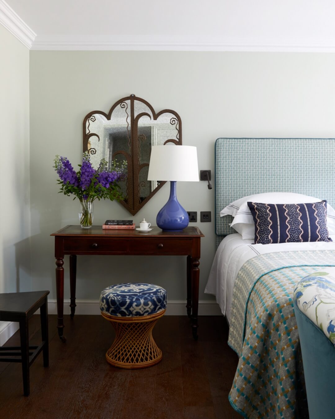 Blue themed boutique hotel room at The Star in Sussex, England featuring vintage furniture and freshly cut purple flowers.