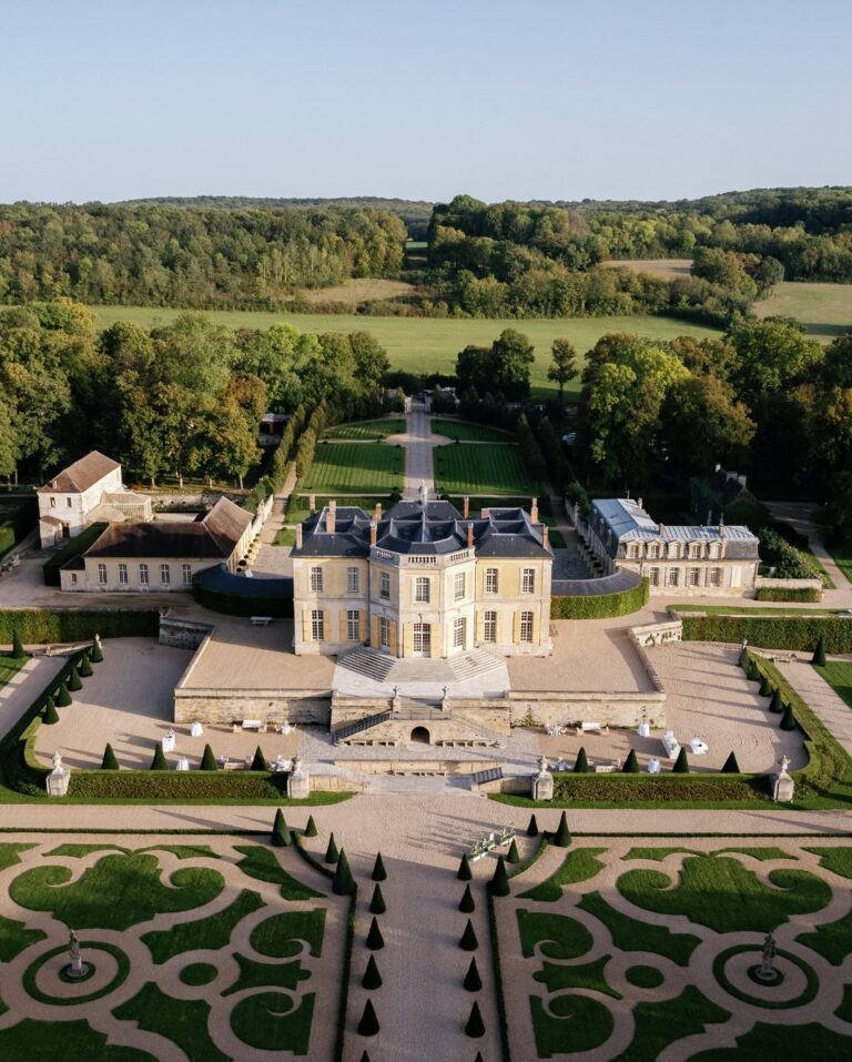 Château de Villette and garden in Sologne, France with manicured hedges, lush grass, and a sprawling estate.