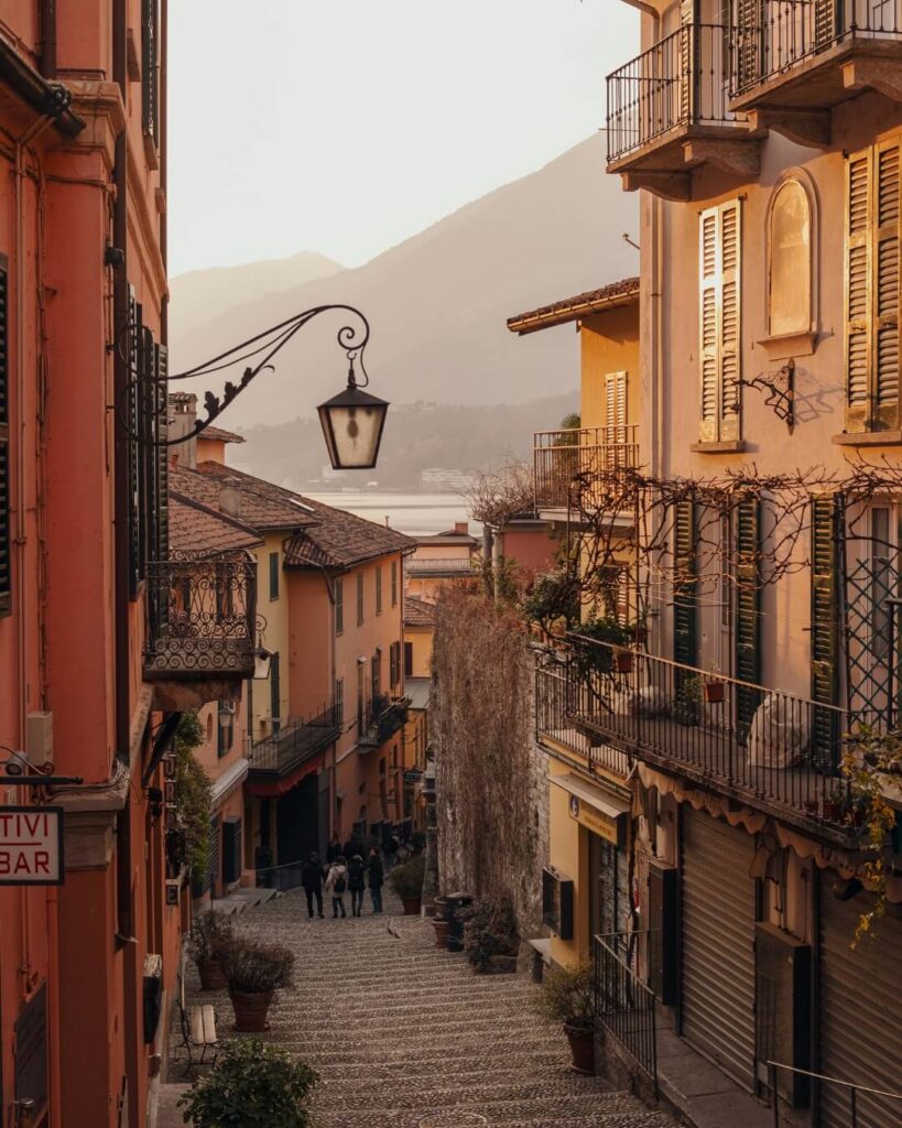 Village side street along Lake Como at golden hour featuring private terraces and stone steps.