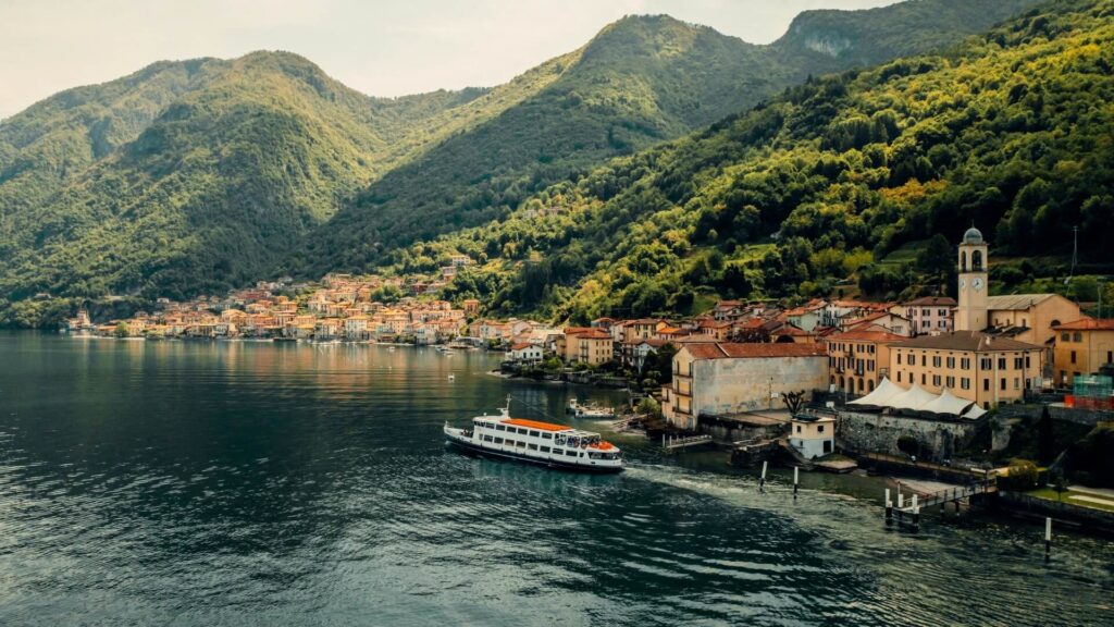 Boats and estates along the lush mountainous landscape of Lake Como, Italy.