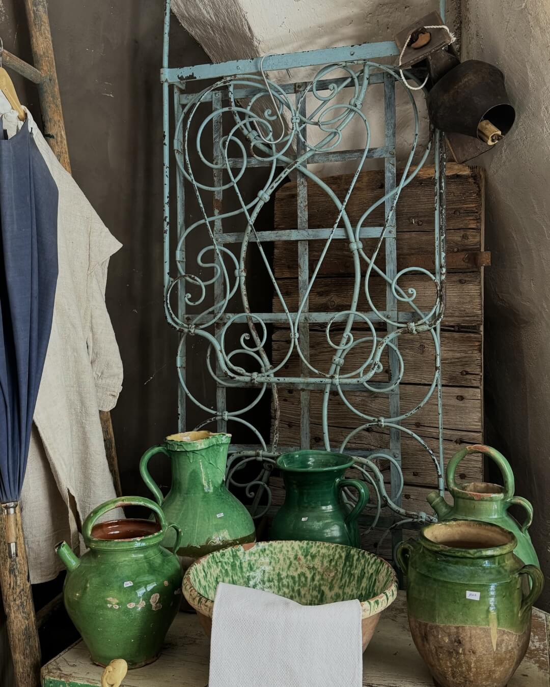 Green glazed ceramic pitchers and bowls on display at an antique shop in Provence.