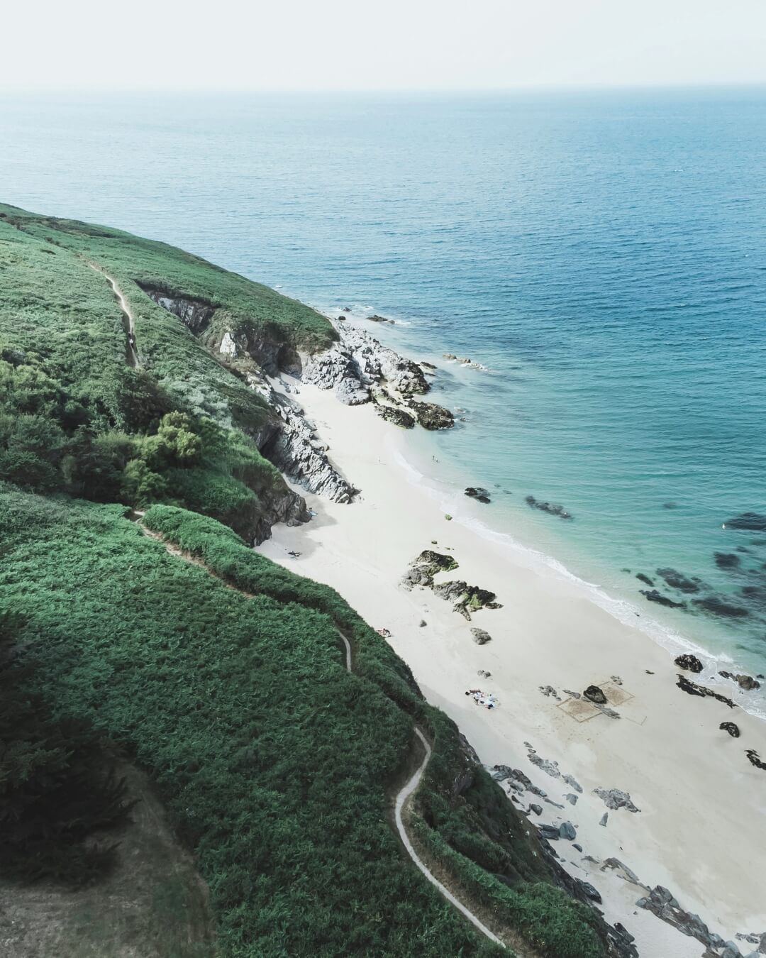 Belle Île en Mer coastline with lush green walking paths beside a white sandy beach.