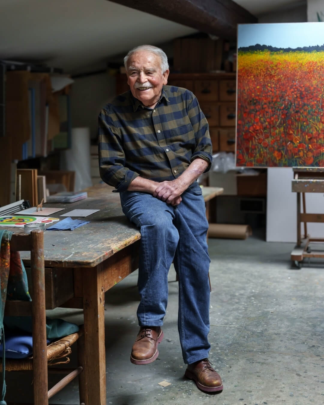 Joseph Bayol posing against a rustic workshop table in his art studio in Provence.