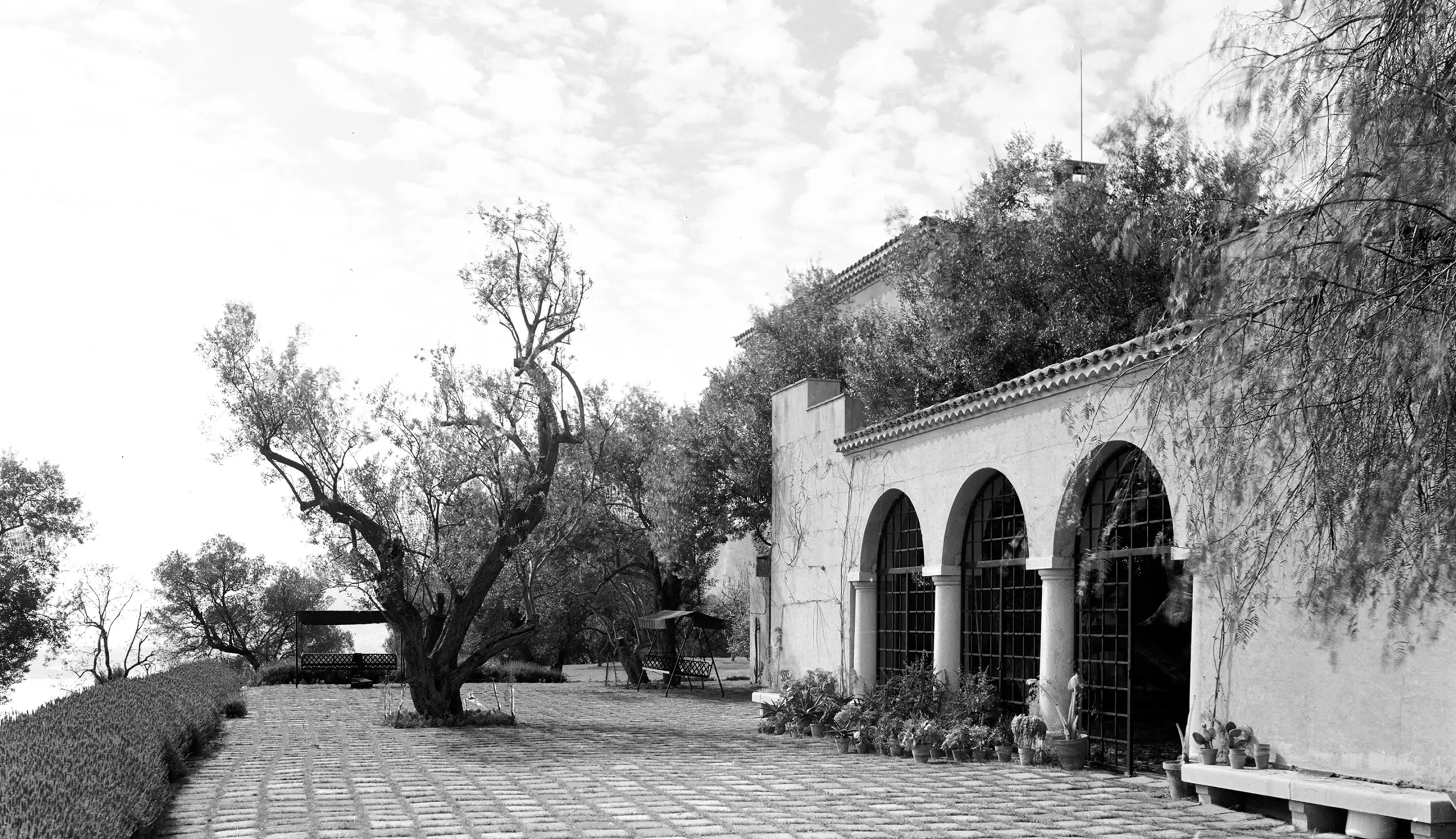 La Pausa Villa terrace garden on the French Riviera with potted plants framing the building exterior.
