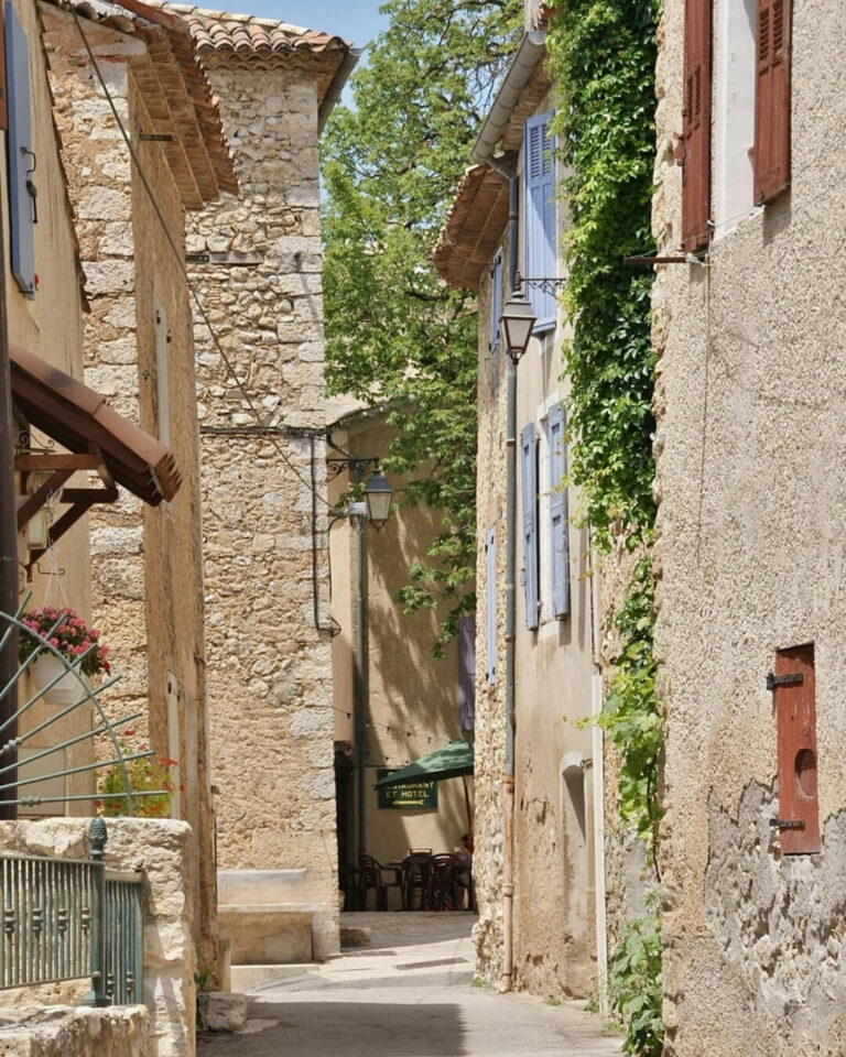 Narrow alley between ancient stone homes in Provence, France.