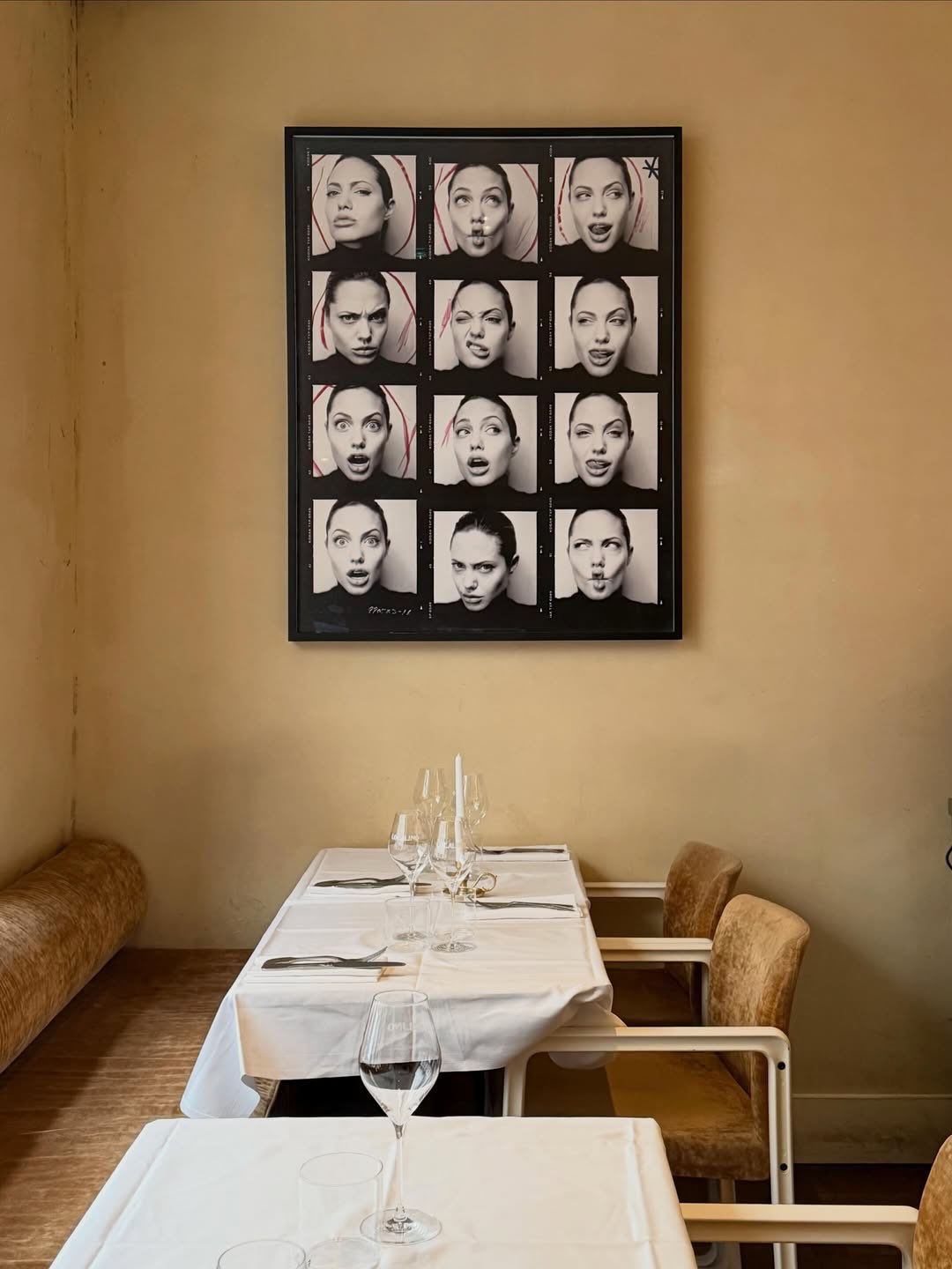 Localino restaurant interior in Paris, featuring plush seating and intimate dining tables beside framed editorial photos.