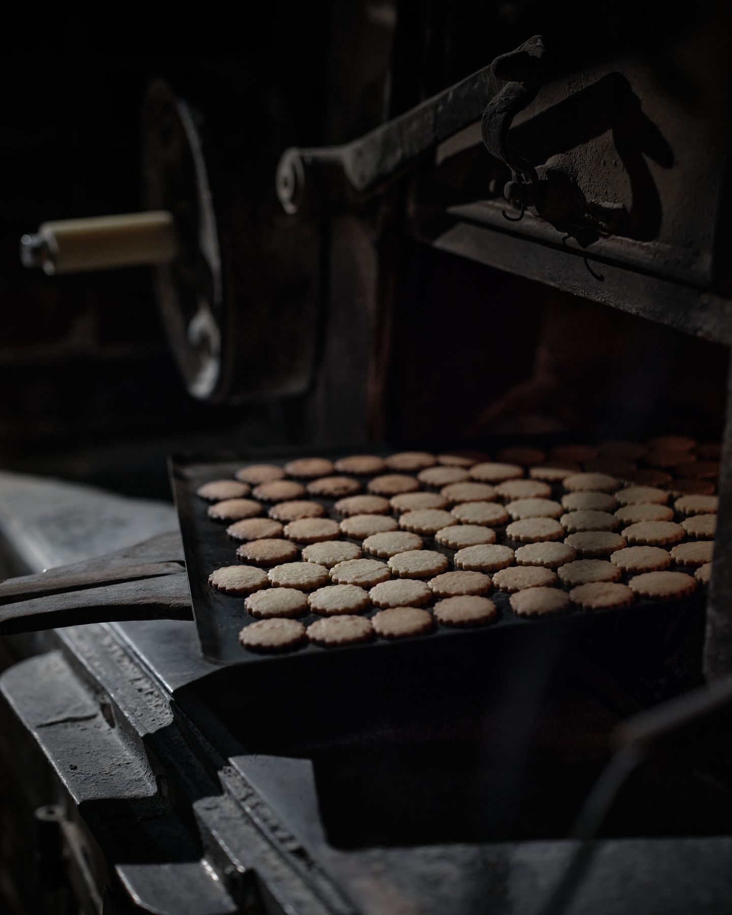 Poilane boulangerie in Paris, featuring a sheet pan of fresh butter cookies pulled from a bakers oven.
