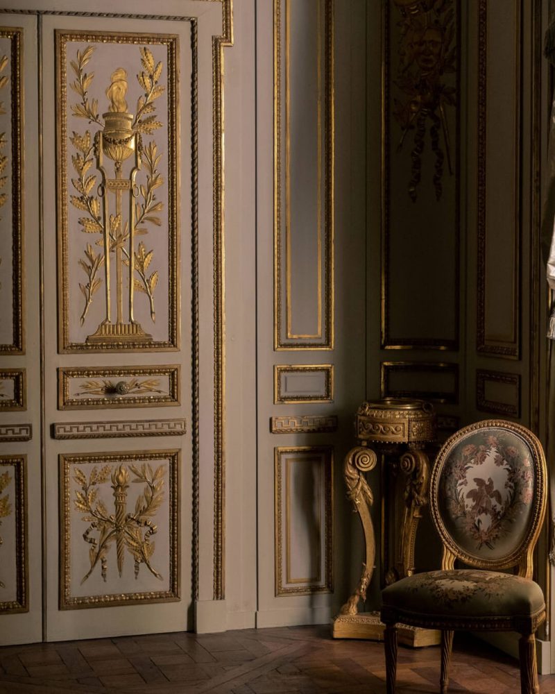 Historic Parisian salon with gold leaf fixtures and an ornately upholstered chair.