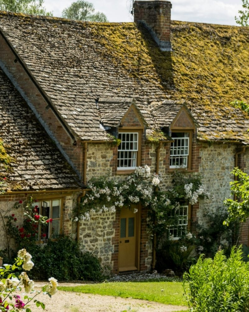 Stone house facade adorned with white flowers above the door.